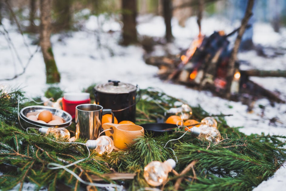 Holiday outdoor picnic with campfire featuring biodegradable plates.
